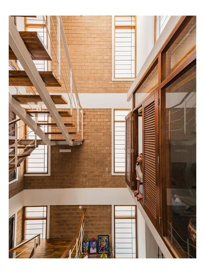 An interior view looking across the central void of a home. The open design and large windows create visual connections between floors and fill the space with natural light.