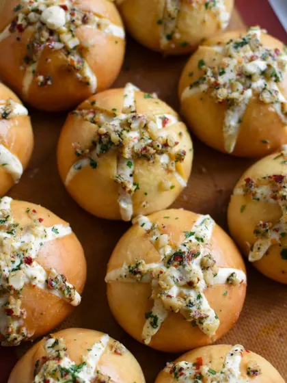 A fresh batch of Korean Cream Cheese Garlic Buns, ready to be packed. The tops are sprinkled with herbs and cheese before baking to golden perfection.