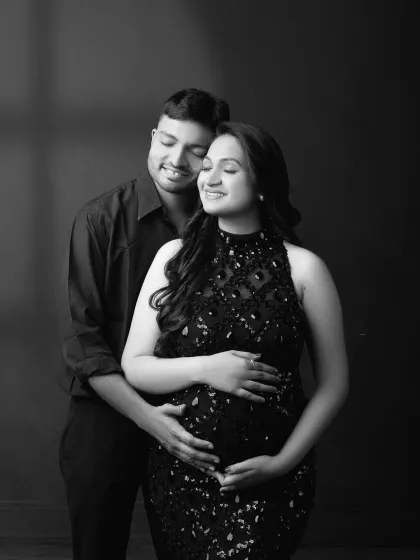 A classic black and white portrait capturing the couple's tender connection. The focus is purely on their emotion and the love they share as they await their little one.