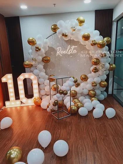 We help businesses celebrate their achievements in style. For this corporate 10th-anniversary event, we created a sophisticated white and gold balloon circle backdrop featuring the company's name and illuminated marquee numbers.