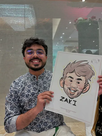 A guest proudly displays his caricature, a quick and fun sketch that captures his likeness with a humorous twist.