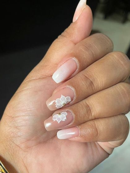 A beautiful ombre nail set with a hand-painted white lotus flower design, creating a serene and elegant look.