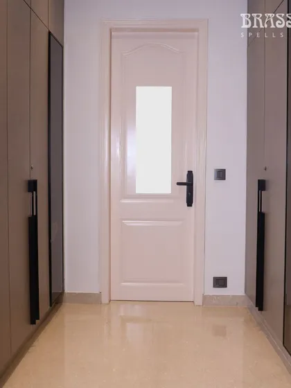 In this walk-in closet at the Juhu residence, our Natali lever handle in Jet Black provides a sleek, modern touch, coordinating with the dark frames of the wardrobe doors.