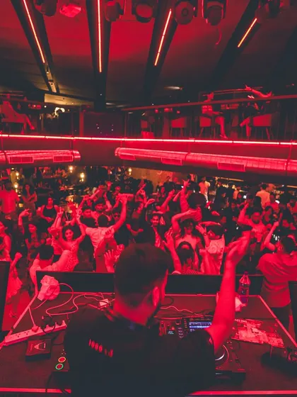 A view from my console as the crowd goes wild under the red lights. This image captures the sheer scale and electric atmosphere I create, turning any corporate gathering into a full-blown party.