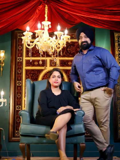 An elegant indoor portrait with a royal theme. The setup includes a grand chandelier, a vintage armchair, and rich textures, creating a look of luxury and sophistication.