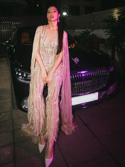 The complete look for Elnaaz Norouzi at the Global Spa Awards. This sheer gown with cape sleeves and feathered trousers was all about glamour, confidence, and making a style statement.