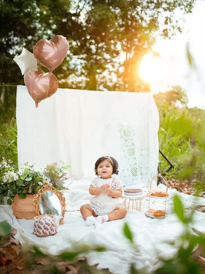 Heart-shaped balloons add a touch of celebration to this dreamy outdoor first birthday session. It's all in the little details.