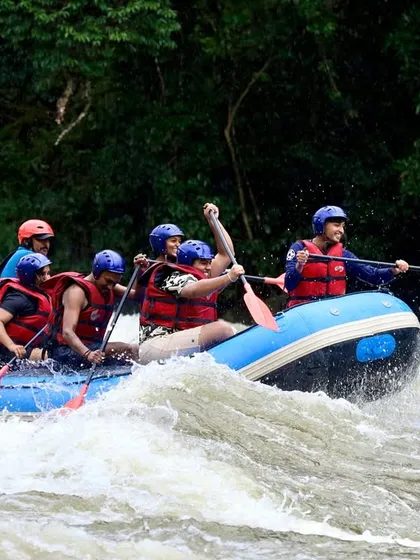 An expert guide steers from the back of the raft, navigating a team through the turbulent waters of the Barapole River. Safety and expert guidance are the cornerstones of all our expeditions.
