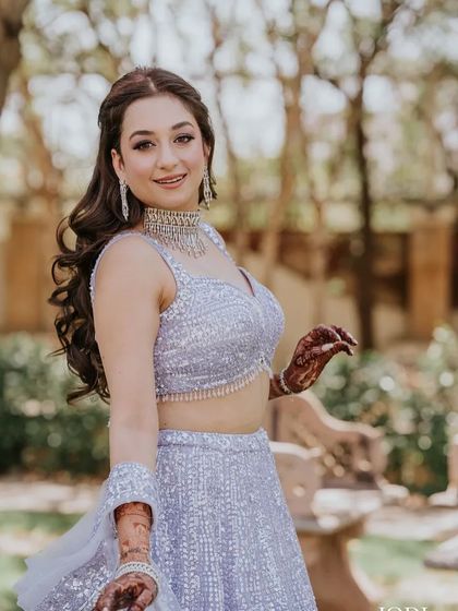 A beautiful client ready for her engagement. I styled her hair in a soft half-updo with voluminous waves, which looks romantic and elegant with her lavender lehenga.