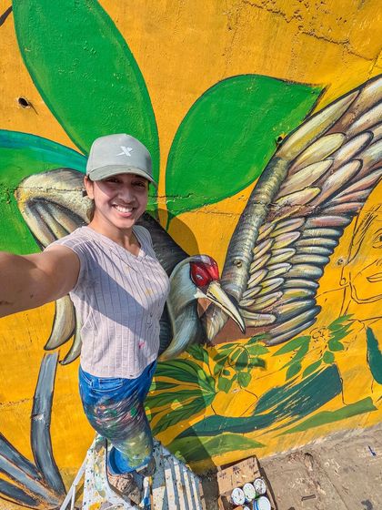A selfie from the scaffolding while painting the details of a Sarus crane in the Coorg mural. Getting up close with the artwork is my favorite part of the process.
