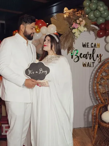 We love capturing the start of a new family journey. This beautiful baby shower moment shows the happy couple, dressed in white, celebrating the upcoming arrival of their baby boy with a sweet "We can bearly wait" theme.