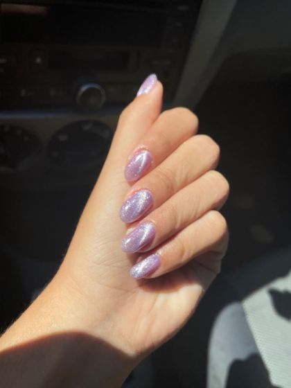 A dreamy lavender cat eye effect on natural nails, shimmering in the sunlight.