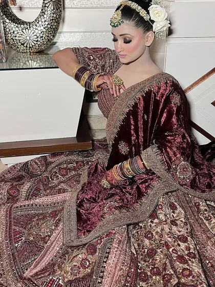 Two portraits of a bride in a deep wine-colored lehenga, focusing on the detailed blouse and the heavy emerald jewellery. Excellent for MUA and jewellery styling inspiration.