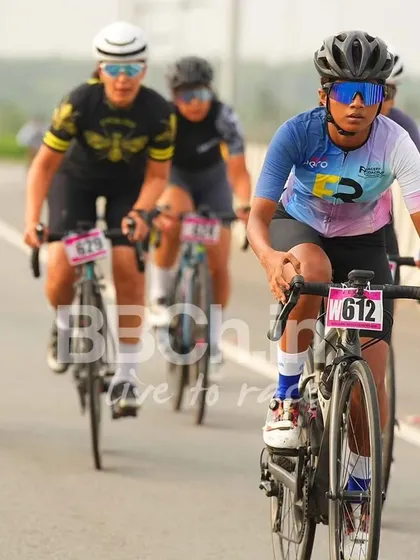 A female rider from the Racefit Coaching team, focused and determined.