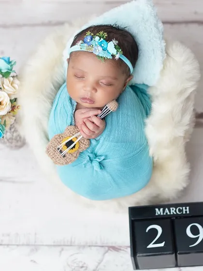 A tiny musician dreaming sweet melodies. Using miniature props like this guitar adds a unique and personal touch to your newborn's portraits.