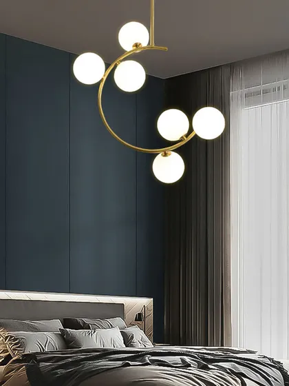 This modern chandelier with globe lights on a curved gold frame is a great choice for a bedroom. It provides soft, diffused light that is perfect for creating a relaxing ambiance. The design is simple yet very stylish.