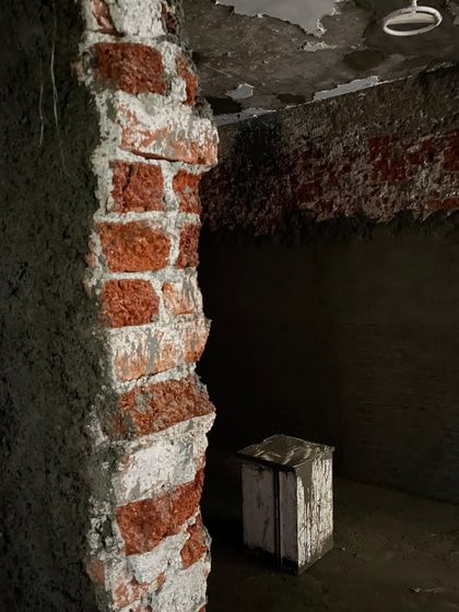 The exposed brick wall of the old shed, which we decided to renovate and expand. This moment of unexpected change became an opportunity to breathe new life into a defunct space and grow our studio.