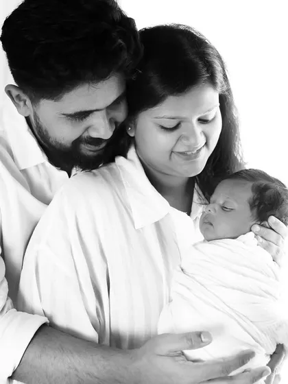 This is how you make memories that last forever. A beautiful, light-filled portrait of new parents gazing at their precious baby.