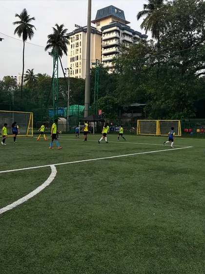 A wide view of a training match in full swing, with players spread across the pitch. This image shows that our training ground is a classroom for character, hustle, and heart.