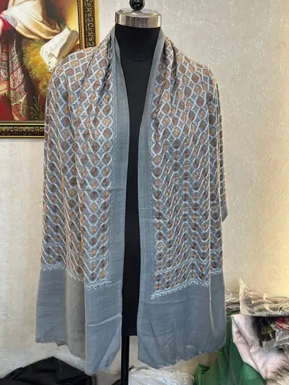 The grey pashmina with gold embroidery, showing the full length and drape of the scarf.