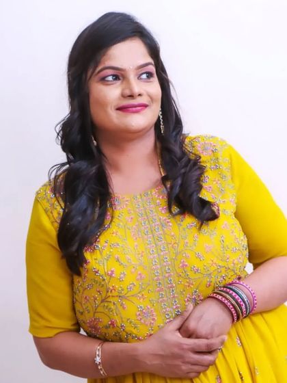 Pratima looking bright and beautiful in a yellow dress for her baby's birthday party. The makeup is fresh, with a pink lip to add a pop of color.