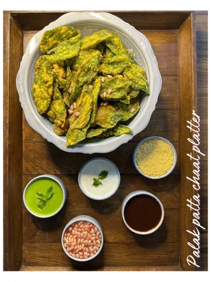 The Palak Patta Chaat platter is a unique and delicious treat. Crispy spinach leaves are fried and then topped with yogurt, chutneys, and spices for a crunchy, tangy, and savory snack.