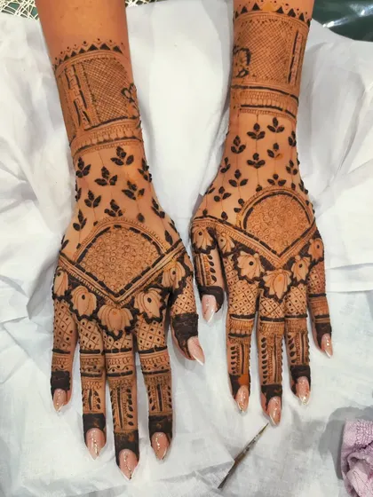 A stylish back-hand design featuring lotus motifs at the base of the fingers. The pattern uses negative space and leafy vines to create a modern and uncluttered yet intricate look.