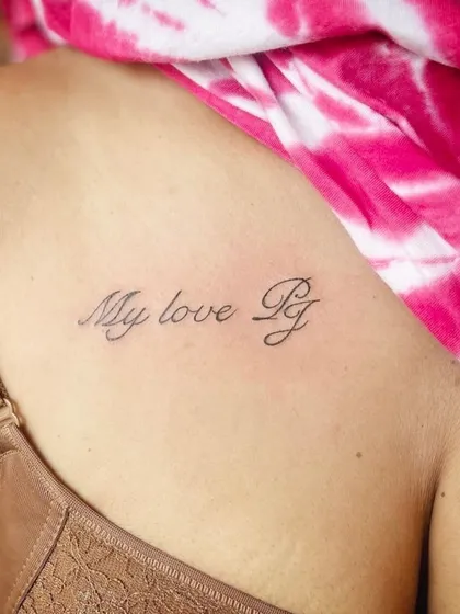 A "My love PJ" script tattoo on the back of the shoulder.