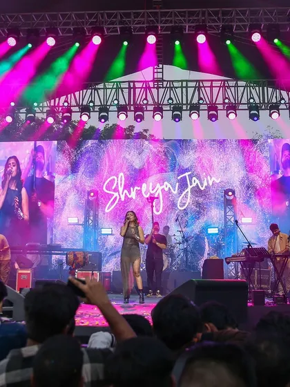 A wide angle of Shreya Jain's performance, showing the full stage production, lighting design, and the massive crowd. This shot gives a sense of the epic scale of the music festivals I cover.
