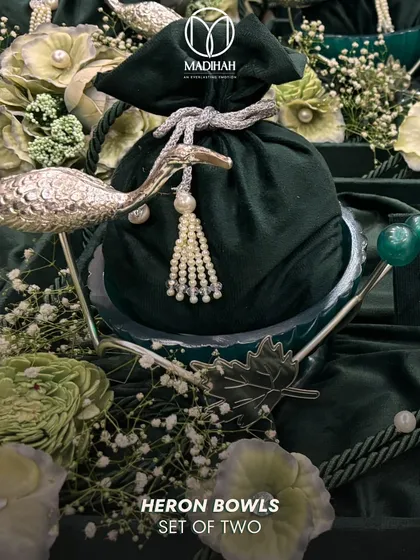 A close-up of the Heron Bowl, a key piece in our wedding collection. The silver-finished heron gracefully holds a velvet potli, all nestled in a bed of flowers, creating a gift that is both elegant and symbolic.
