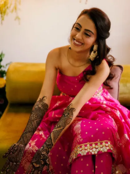 A radiant bride in a stunning pink outfit, her arms beautifully decorated with my intricate mehendi designs.