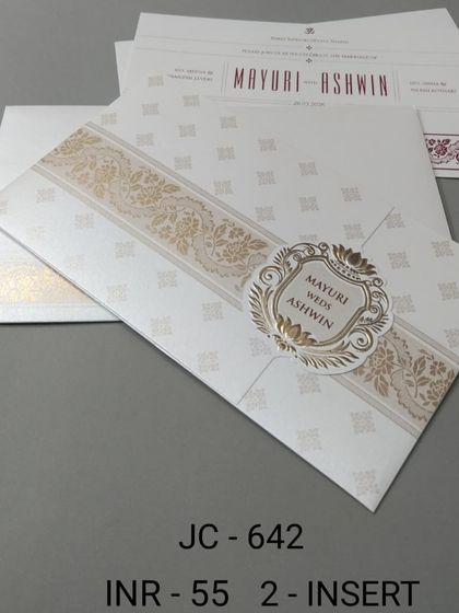 A simple and elegant white invitation with a gold patterned band. The design is clean and classic, with inserts available to match.
