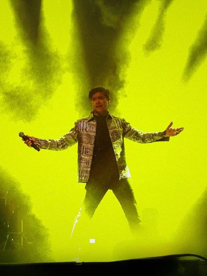 An atmospheric shot of Shaan enveloped in yellow stage smoke and light. Our production team uses effects to create dramatic and memorable visual moments.