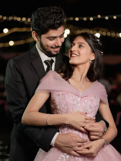 A happy and natural portrait of a newly engaged couple. Her pink gown and his classic suit make for a modern and elegant look.