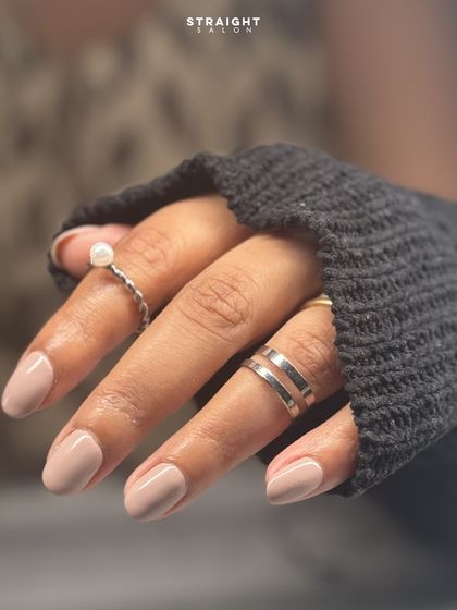 A close-up of the flawless nude manicure. This is the perfect look for everyday elegance and professionalism.