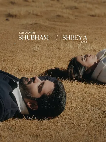 An artistic shot of a couple lying on the sparse grasslands of Ladakh, finding peace and connection under the vast sky. This is a quiet, contemplative pre-wedding portrait.