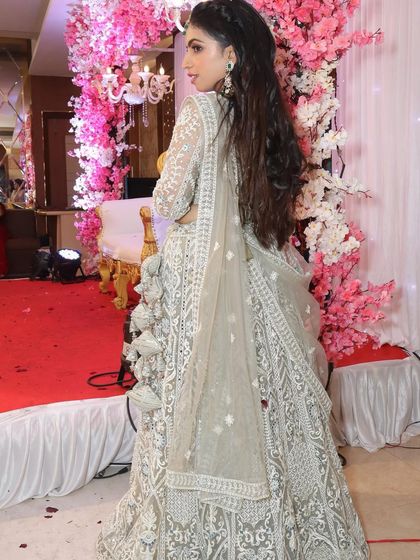 A client showing the back detail of her beautiful silver-grey lehenga.