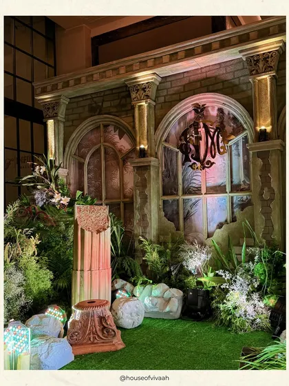 A mandap designed to look like ancient ruins reclaimed by nature. This unique setup at Fairmont Mumbai combines architectural elements with lush greenery and soft candlelight for a truly enchanting and story-driven ceremony.