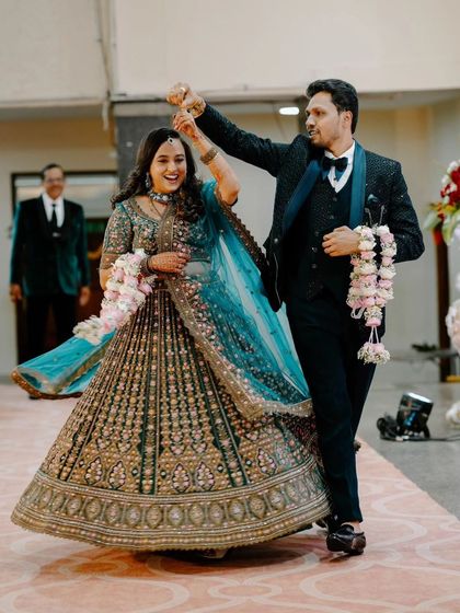 A candid, action-filled shot of the couple's entrance. The groom giving his bride a twirl shows their fun-loving personalities and the celebratory mood.
