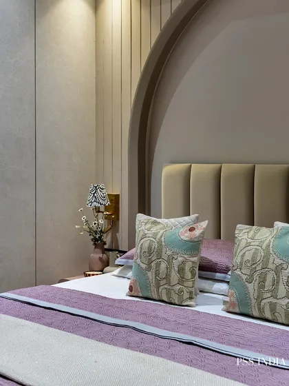 Another angle of the mauve bedroom, focusing on the interplay between the arched alcove, the fluted wall panels, and the soft lighting from the bedside lamp.