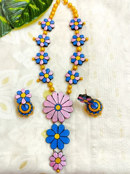 The same three-layer floral necklace, here in a playful pink and blue color scheme. The contrasting colors make this a fun and eye-catching piece.