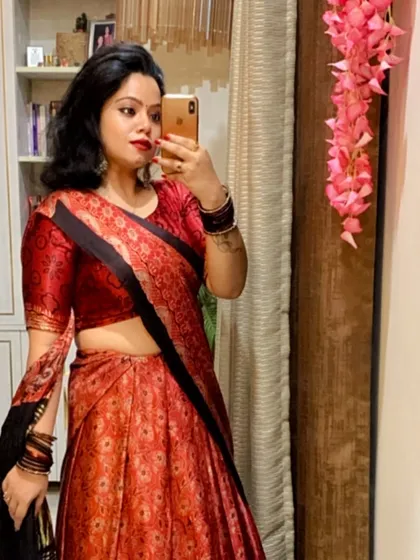 A mirror selfie showing a red and black lehenga, perfect for checking your look before heading to a Navratri event.