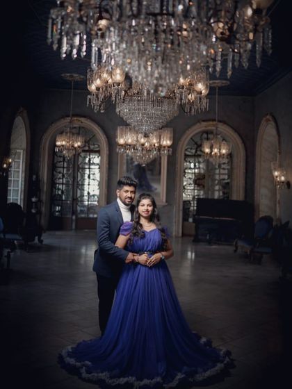 An elegant and classic pre-wedding portrait. The couple looks timeless in this grand setting, with the blue gown adding a touch of royal color.