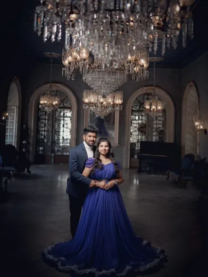 An elegant and classic pre-wedding portrait. The couple looks timeless in this grand setting, with the blue gown adding a touch of royal color.