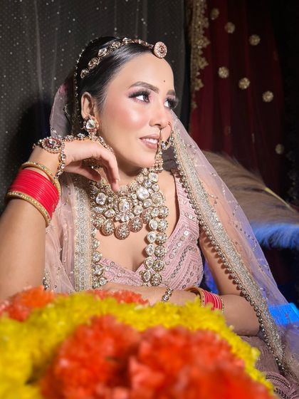 A soft, elegant makeup look on a bride in a pastel pink lehenga. Perfect for a day wedding.