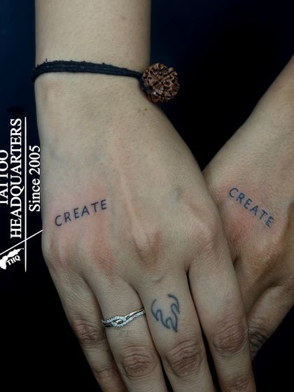 A matching "CREATE" tattoo on the hands of two people, symbolizing a shared passion for creativity.