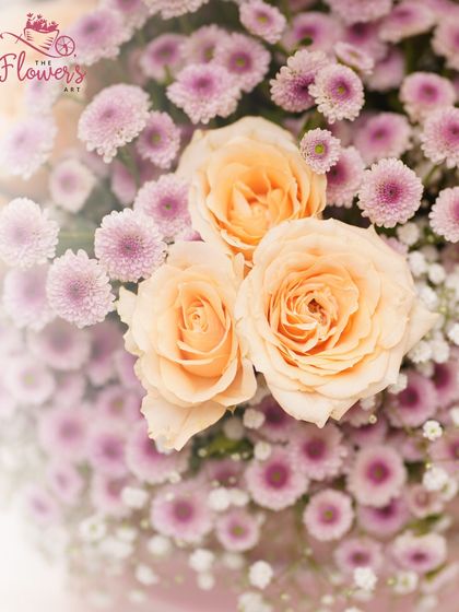 A detailed shot focusing on the soft peach roses nestled among a bed of pink daisies. This view shows the quality and freshness of the flowers I use in every birthday bouquet.
