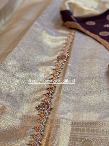 A video showcasing a deep wine-colored blouse with temple jewellery embroidery along the neckline and sleeves.