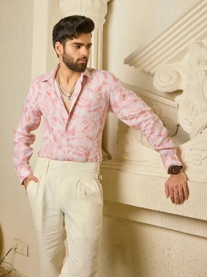 A full view of the pink linen shirt and cream trousers ensemble. It’s a look that speaks of relaxed luxury and effortless style.