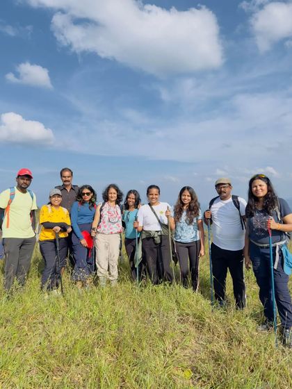 A group of trekkers posing on the green hills.